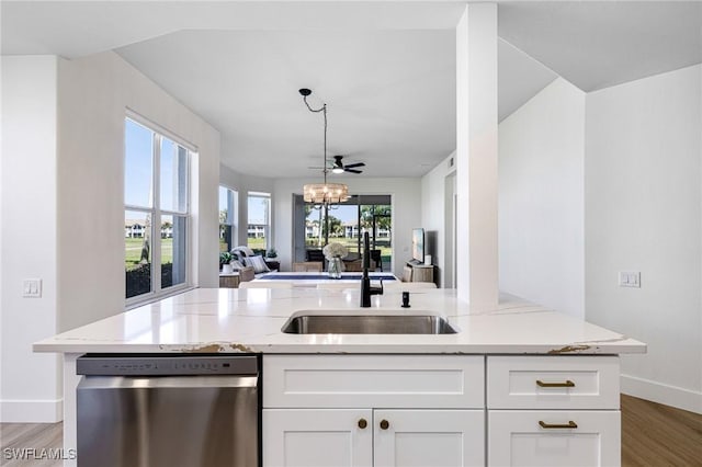 16451 Millstone Cir Unit 101, Fort Myers, FL 33908 - kitchen with stainless steel dishwasher, open floor plan, a sink, baseboards, and light stone countertops