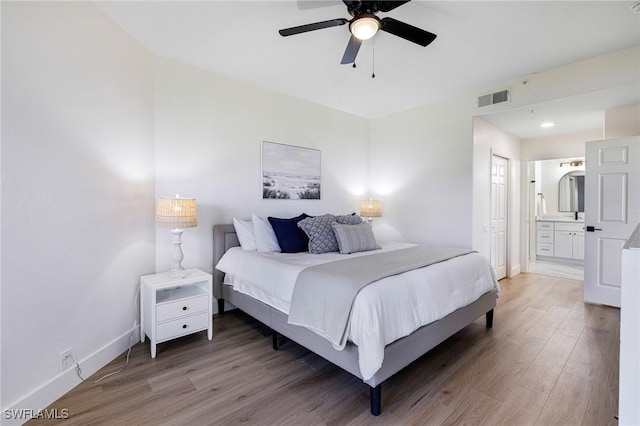 16451 Millstone Cir Unit 101, Fort Myers, FL 33908 - bedroom with light wood-style floors, baseboards, connected bathroom, and a ceiling fan