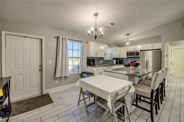2303 NE 7th Ave, Cape Coral, FL 33909 - kitchen featuring an inviting chandelier, stone countertops, stainless steel appliances, backsplash, and visible vents