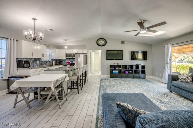2303 NE 7th Ave, Cape Coral, FL 33909 - living area with lofted ceiling, visible vents, light wood finished floors, and baseboards