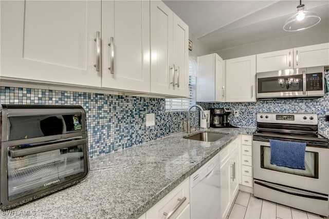 2303 NE 7th Ave, Cape Coral, FL 33909 - kitchen featuring white cabinets, tasteful backsplash, stainless steel appliances, and a sink