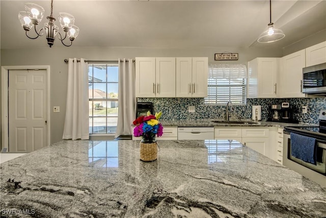 2303 NE 7th Ave, Cape Coral, FL 33909 - kitchen with light stone countertops, a sink, backsplash, and appliances with stainless steel finishes