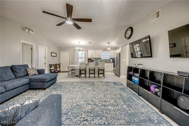 2303 NE 7th Ave, Cape Coral, FL 33909 - living room with vaulted ceiling, ceiling fan with notable chandelier, light wood-style flooring, baseboards, and visible vents