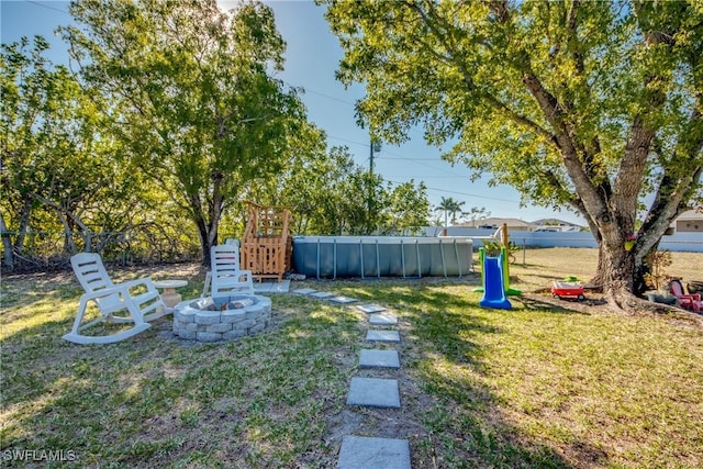 2303 NE 7th Ave, Cape Coral, FL 33909 - view of yard with an outdoor pool, an outdoor fire pit, and fence