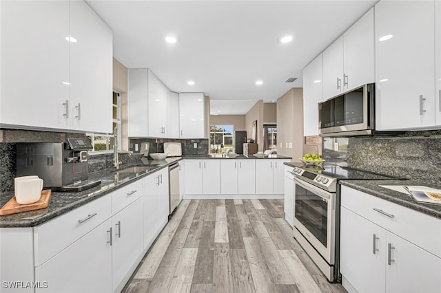 13471 Bridgeford Ave, Bonita Springs, FL 34135 - kitchen with white cabinets, a sink, appliances with stainless steel finishes, and light wood finished floors