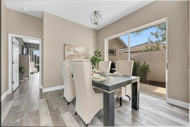 13471 Bridgeford Ave, Bonita Springs, FL 34135 - dining room featuring baseboards, light wood-style floors, and a chandelier