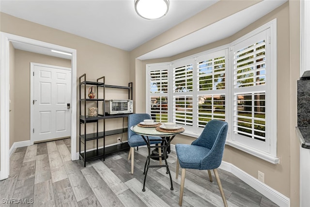 13471 Bridgeford Ave, Bonita Springs, FL 34135 - dining area featuring cooling unit, baseboards, and wood finished floors