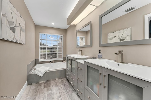 13471 Bridgeford Ave, Bonita Springs, FL 34135 - bathroom with vanity, a bath, recessed lighting, visible vents, and wood finished floors