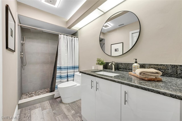 13471 Bridgeford Ave, Bonita Springs, FL 34135 - bathroom with a tile shower, toilet, vanity, wood finished floors, and visible vents