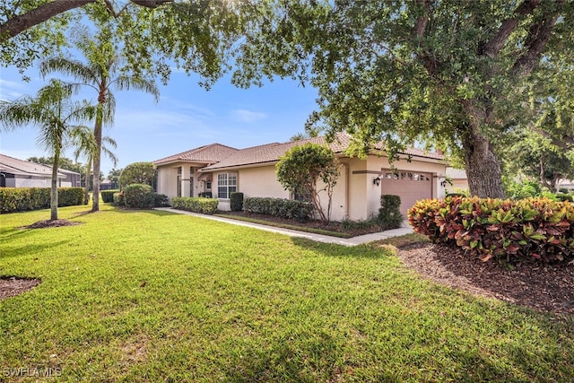 13471 Bridgeford Ave, Bonita Springs, FL 34135 - view of front facade with a front lawn, stucco siding, and a garage