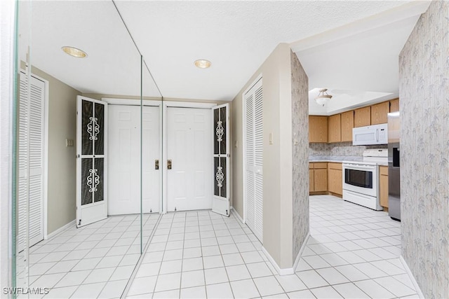 801 Islamorada Blvd Unit 21A, Punta Gorda, FL 33955 - kitchen featuring white appliances, light tile patterned floors, light countertops, and baseboards