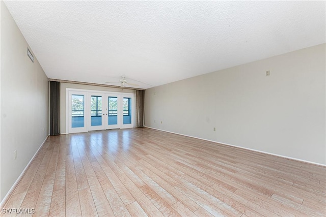 801 Islamorada Blvd Unit 21A, Punta Gorda, FL 33955 - empty room with light wood-style floors, a textured ceiling, a ceiling fan, and baseboards