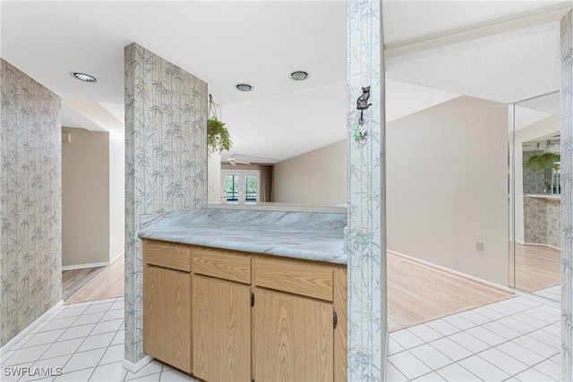801 Islamorada Blvd Unit 21A, Punta Gorda, FL 33955 - kitchen featuring light countertops, light brown cabinets, light tile patterned floors, baseboards, and wallpapered walls