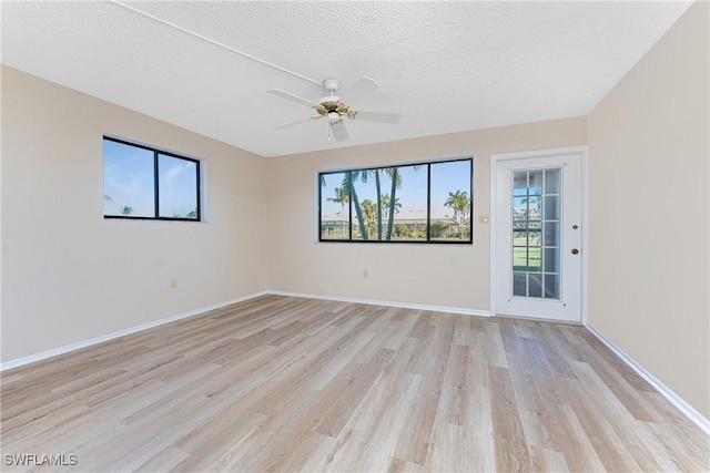 801 Islamorada Blvd Unit 21A, Punta Gorda, FL 33955 - empty room with light wood finished floors, a textured ceiling, a ceiling fan, and baseboards