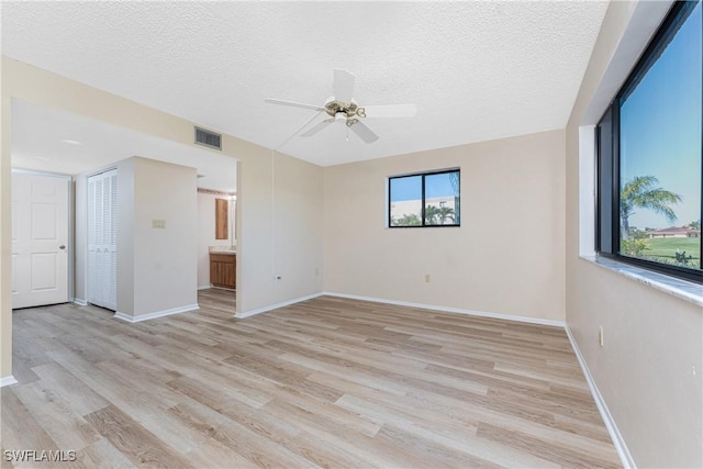 801 Islamorada Blvd Unit 21A, Punta Gorda, FL 33955 - unfurnished room featuring a textured ceiling, ceiling fan, light wood-style floors, and baseboards