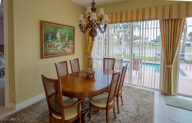 tiled dining area featuring baseboards and a notable chandelier