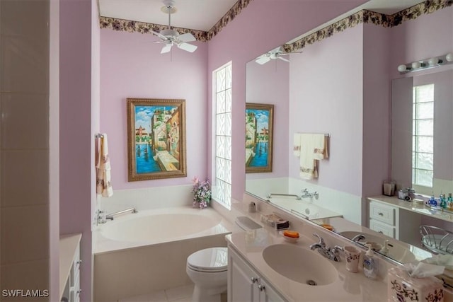 full bathroom with toilet, a garden tub, vanity, and a ceiling fan