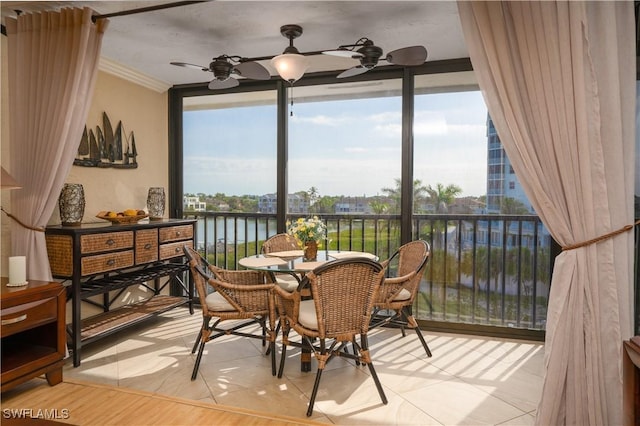 dining area with expansive windows, a water view, ornamental molding, and ceiling fan