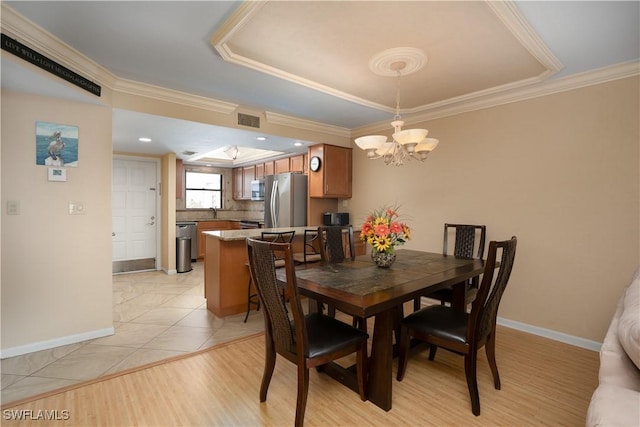 dining area featuring baseboards, a notable chandelier, visible vents, and ornamental molding