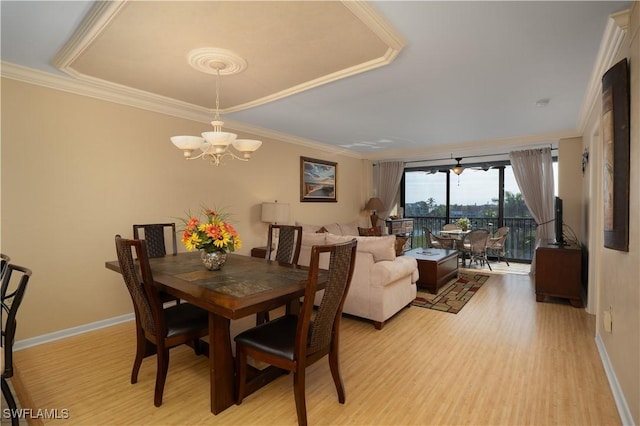 dining space with baseboards, an inviting chandelier, crown molding, and light wood finished floors