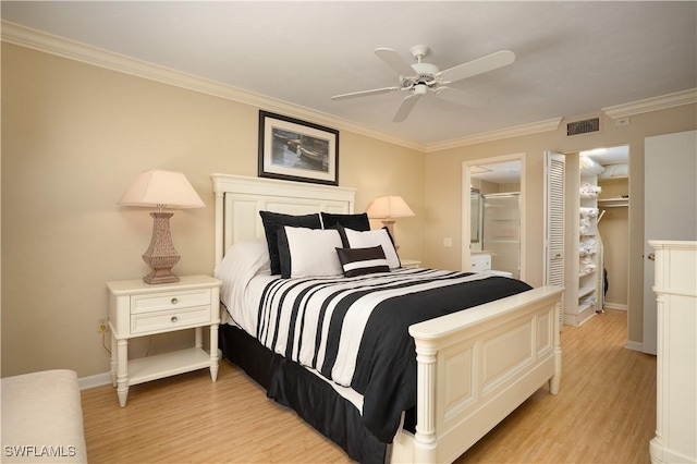 bedroom with baseboards, visible vents, light wood-style floors, and ornamental molding