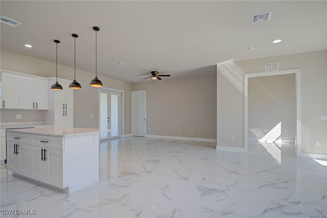 kitchen with marble finish floor, visible vents, and white cabinetry