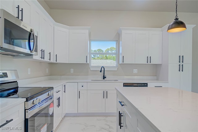 kitchen with white cabinetry, marble finish floor, a sink, pendant lighting, and appliances with stainless steel finishes