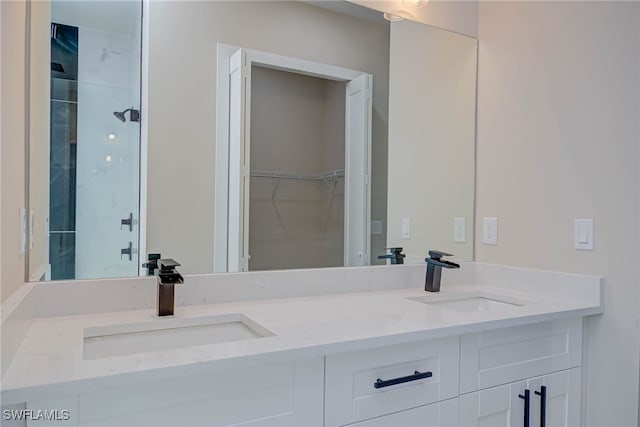 bathroom featuring double vanity, a sink, and a spacious closet