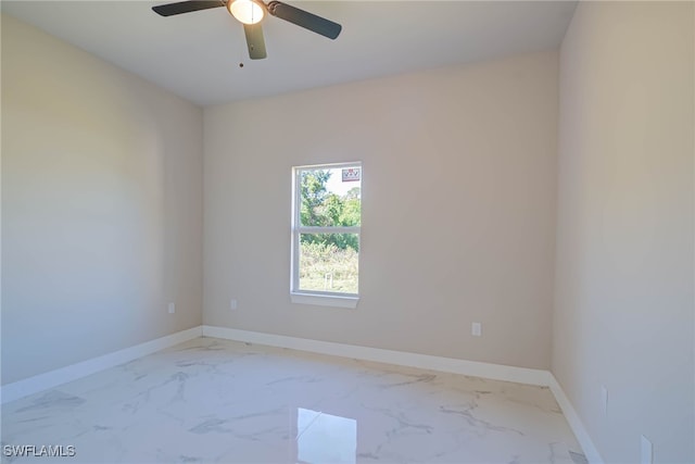 unfurnished room featuring baseboards, marble finish floor, and ceiling fan