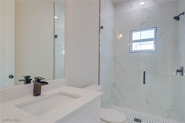 full bathroom featuring toilet, vanity, and a marble finish shower