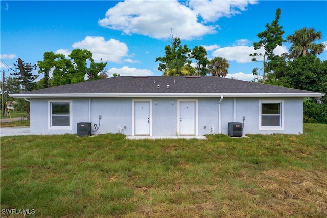 1861 Lillie St, Fort Myers, FL 33916 - back of property featuring stucco siding, cooling unit, and a lawn