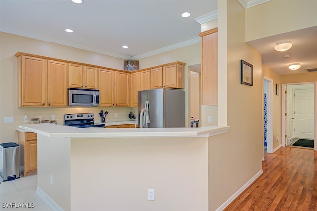 kitchen with light brown cabinetry, stainless steel appliances, baseboards, and light countertops