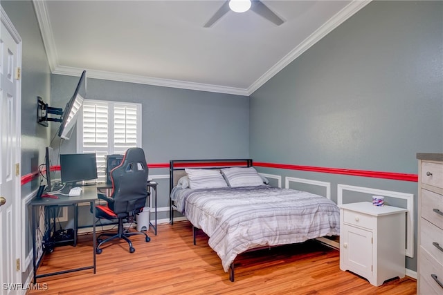 bedroom with wainscoting, ornamental molding, and light wood finished floors