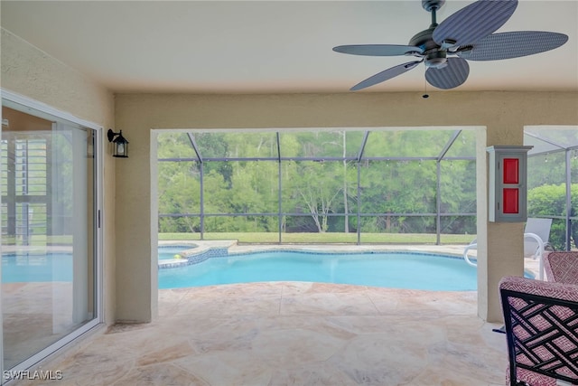 view of pool featuring a patio, a pool with connected hot tub, a ceiling fan, and a lanai
