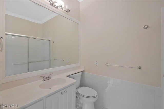 6044 Andros Way, Naples, FL 34119 - full bath featuring tile walls, a wainscoted wall, a shower, toilet, and vanity