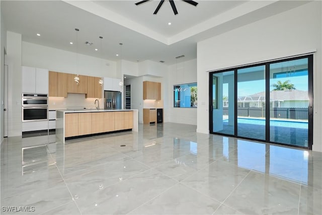 unfurnished living room featuring a sink, ceiling fan, a towering ceiling, visible vents, and recessed lighting