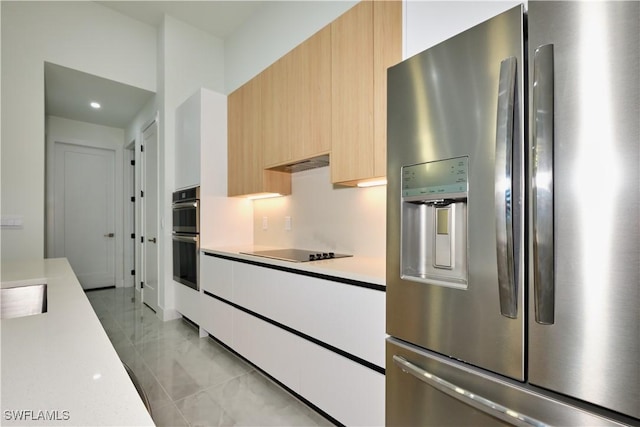 kitchen with modern cabinets, light brown cabinets, stainless steel appliances, and light countertops