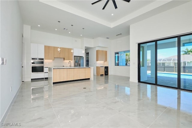 unfurnished living room with marble finish floor, a high ceiling, a sink, and baseboards