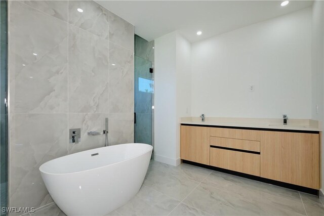 full bath featuring recessed lighting, a shower stall, marble finish floor, a sink, and a soaking tub