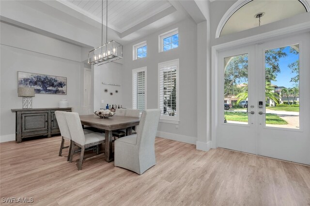 339 Saddlebrook Ln SE, Naples, FL 34110 - dining room with light wood-style floors, a chandelier, french doors, baseboards, and a high ceiling