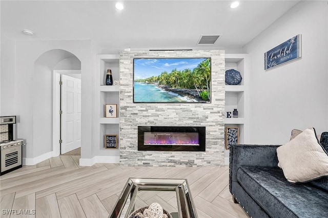 living area with recessed lighting, baseboards, built in shelves, visible vents, and a fireplace