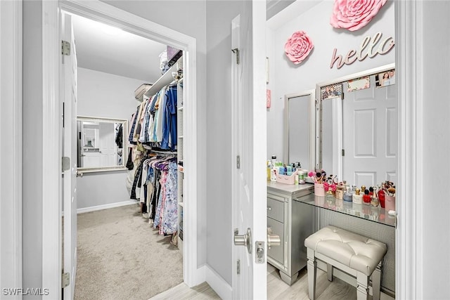 walk in closet featuring light carpet