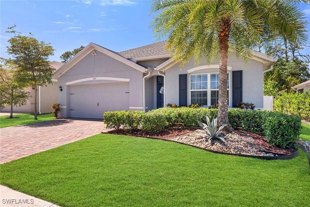 single story home featuring driveway, stucco siding, a front yard, and an attached garage