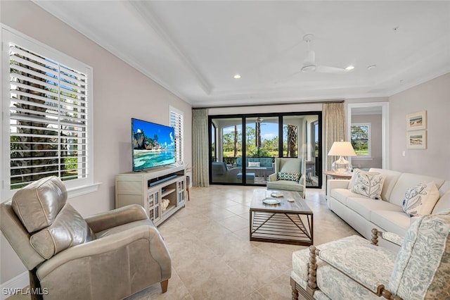 living room featuring a tray ceiling, a wealth of natural light, recessed lighting, and crown molding