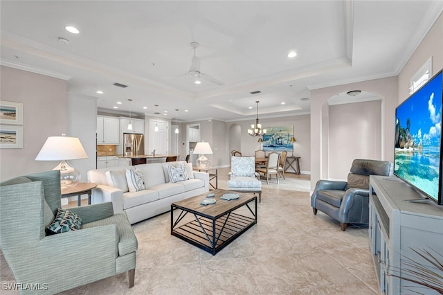 living area with crown molding, recessed lighting, a raised ceiling, arched walkways, and ceiling fan with notable chandelier