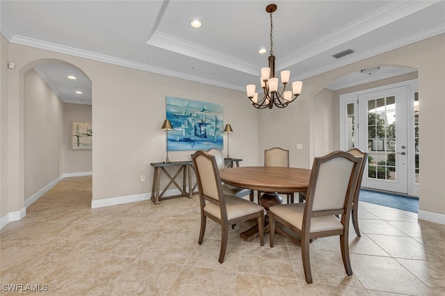 dining area featuring visible vents, ornamental molding, a raised ceiling, arched walkways, and a notable chandelier