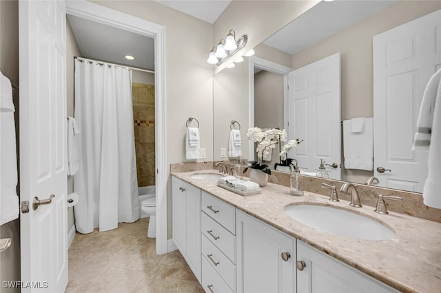full bath featuring double vanity, a sink, toilet, and tile patterned floors