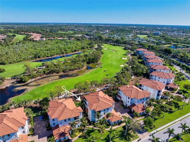drone / aerial view with a residential view, golf course view, and a water view