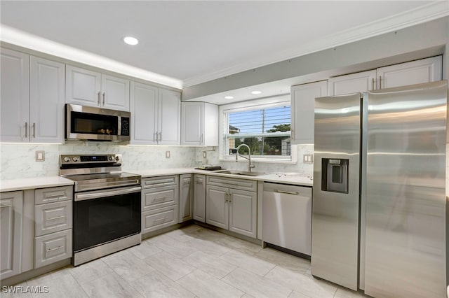 2324 Westwood Rd, North Fort Myers, FL 33917 - kitchen featuring crown molding, appliances with stainless steel finishes, a sink, decorative backsplash, and gray cabinetry