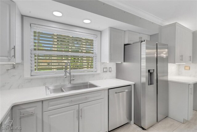 2324 Westwood Rd, North Fort Myers, FL 33917 - kitchen featuring white cabinetry, light countertops, a sink, stainless steel appliances, and backsplash